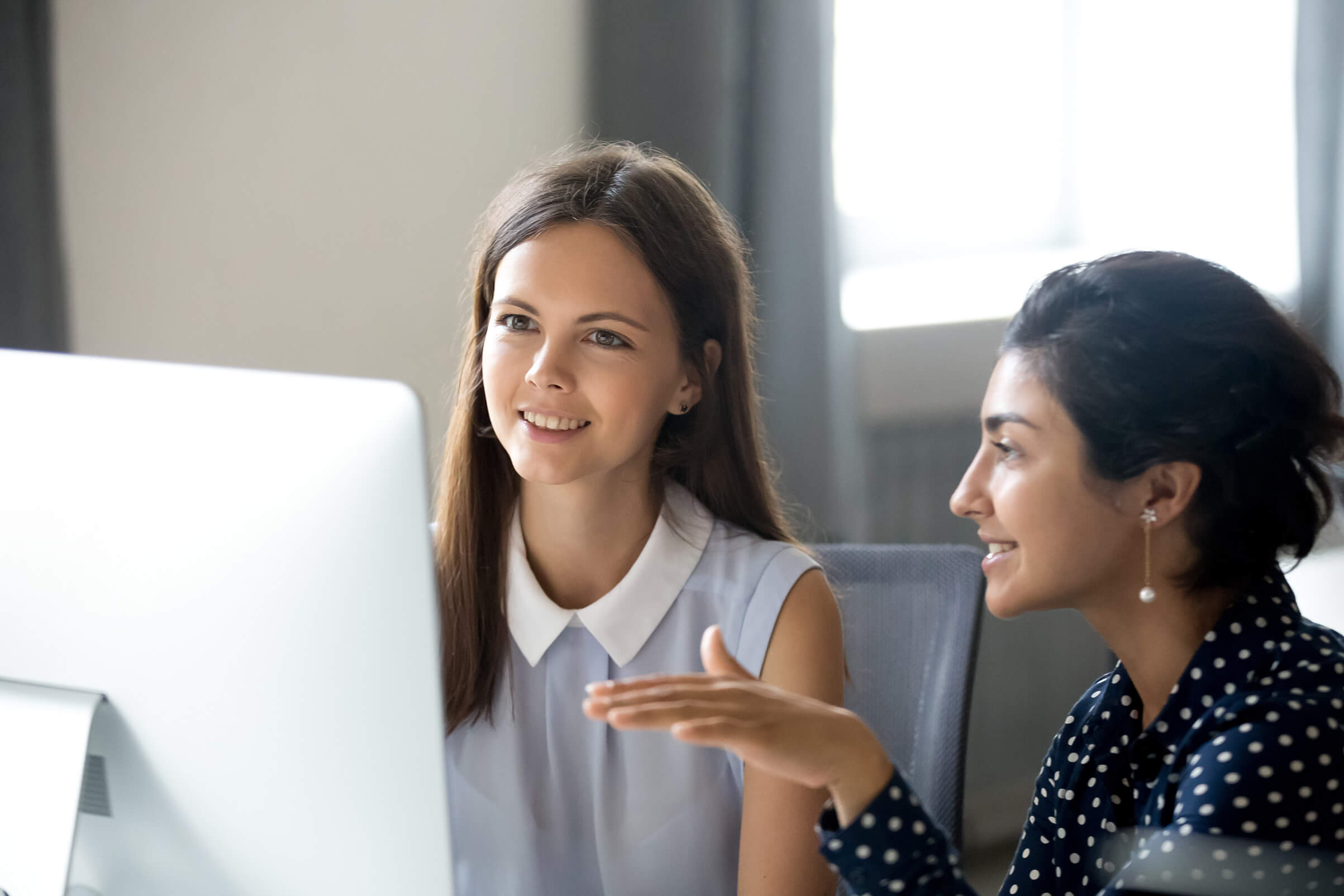 Zwei junge Frauen vor einem Computerbildschirm