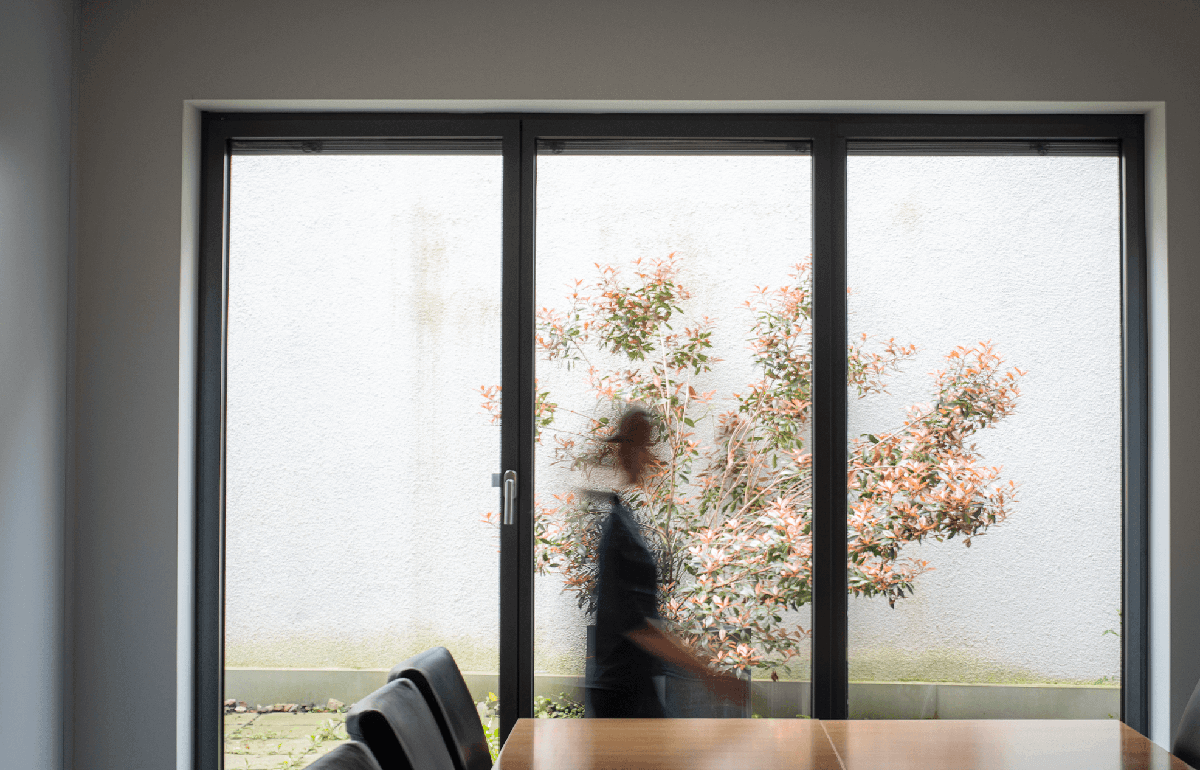 Person läuft vor einem Fenster im Besprechungsraum verschwommen am Betrachter vorbei