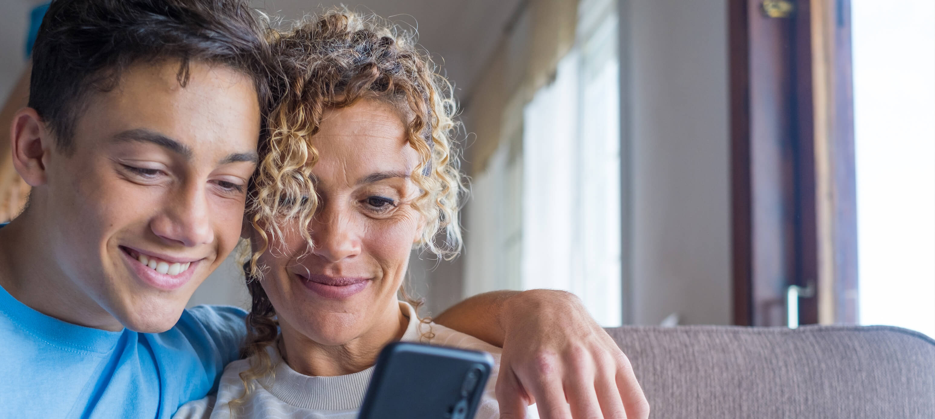 Mutter und Sohn informieren sich am Handy über Steuerberaterberuf