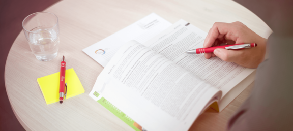 Person hat ein Buch mit Gesetzestexten aufgeschlagen und liest darin